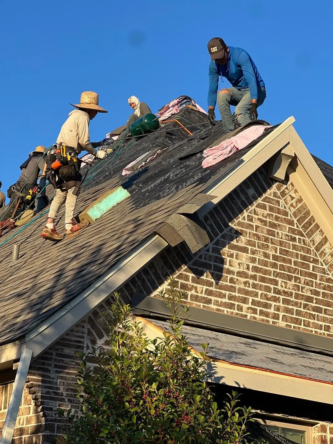 Roofing crew replacing shingles on a home