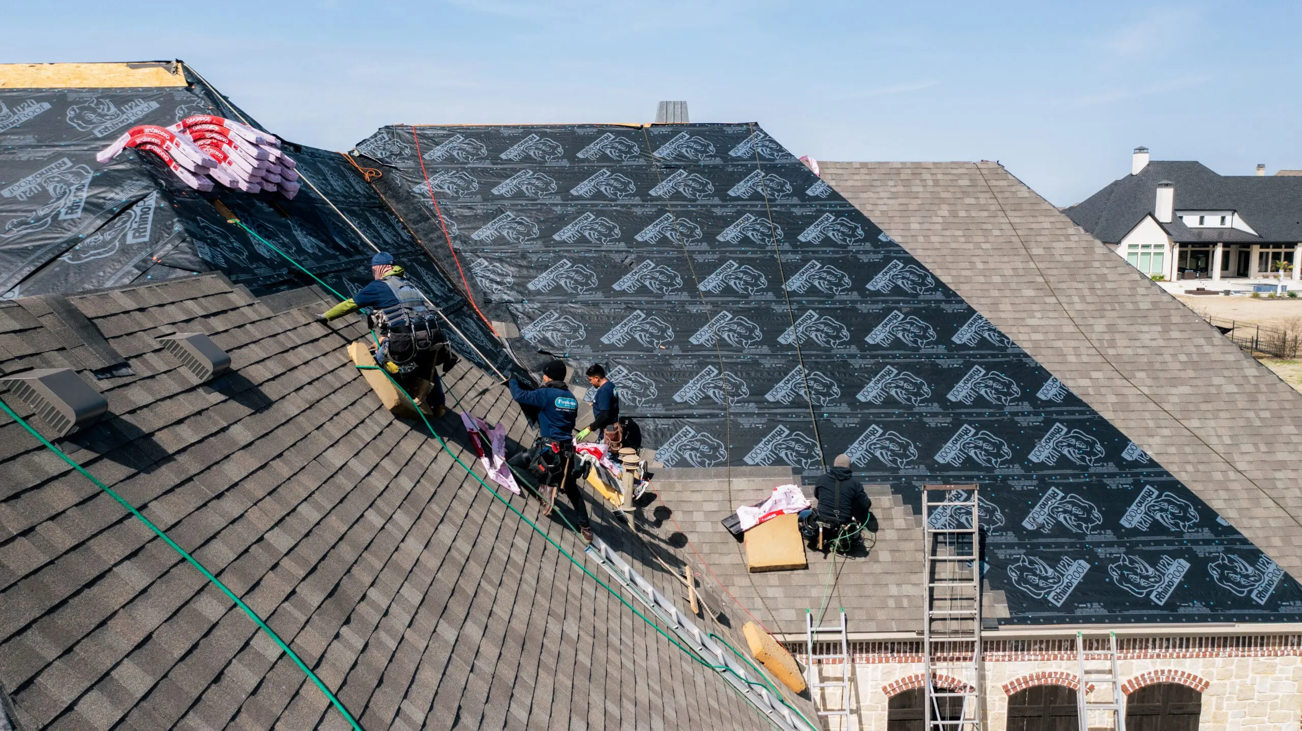 Aerial view of a roofing crew replacing shingles