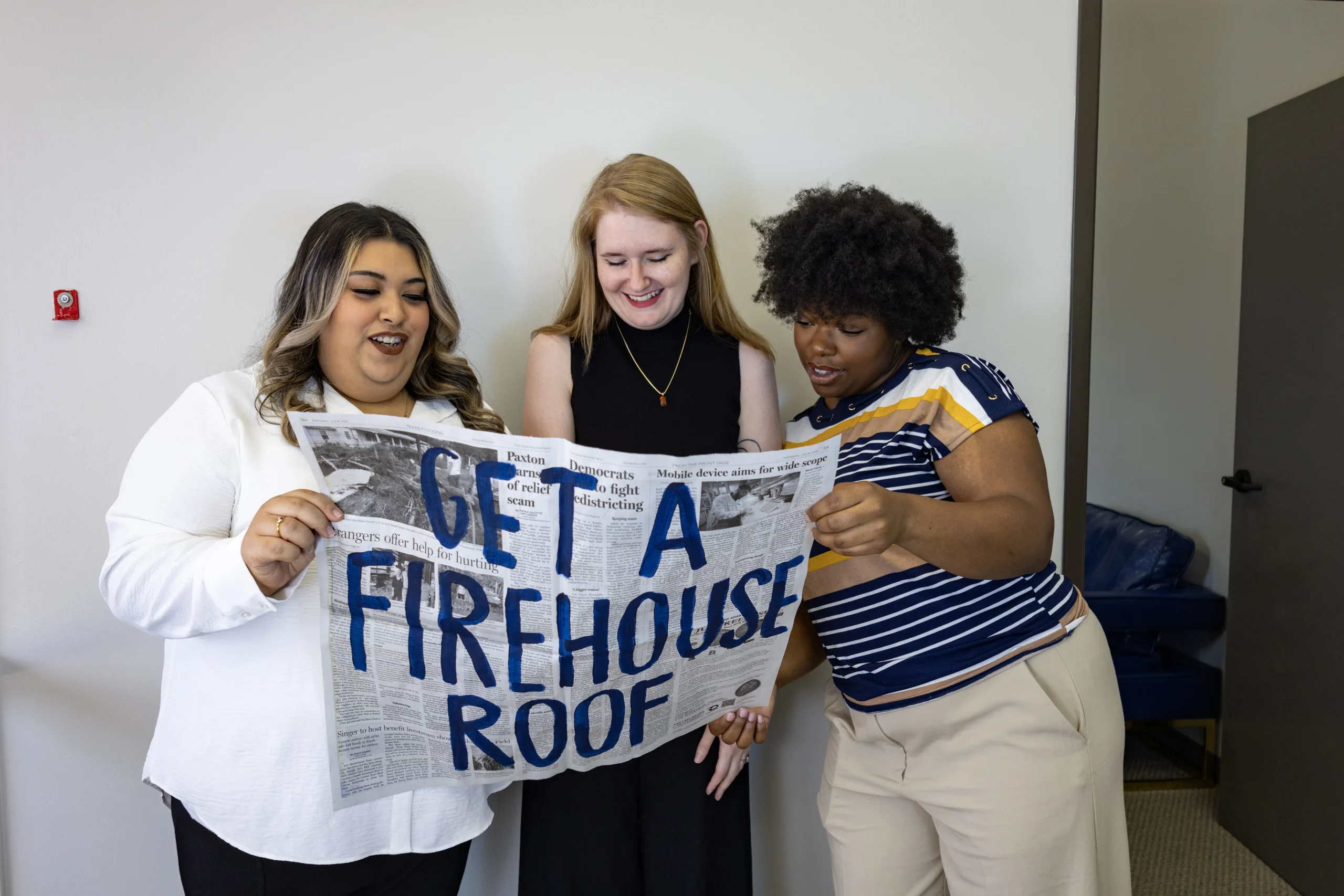 Firehouse Roofing team with a Get a Firehouse Roof sign