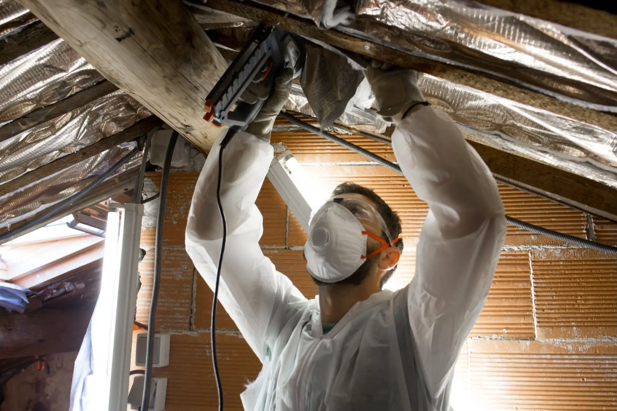 Technician installing radiant barrier in an attic
